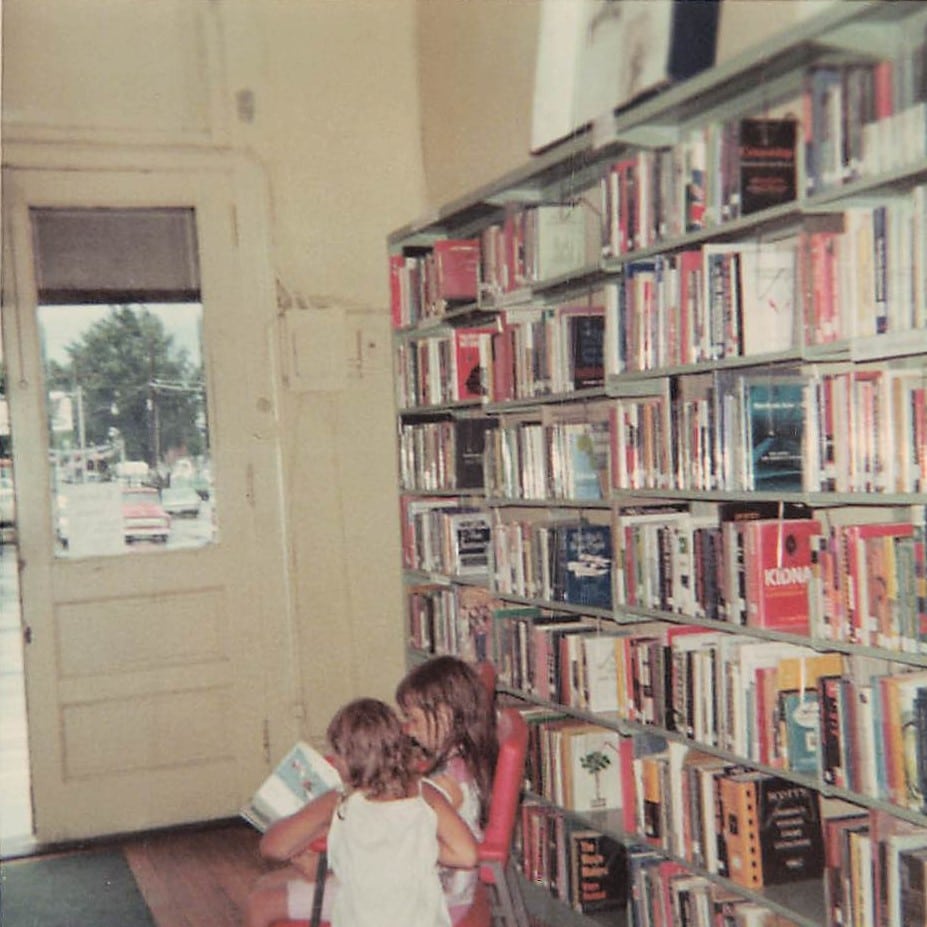 Two children look at a book, circa 1967.
