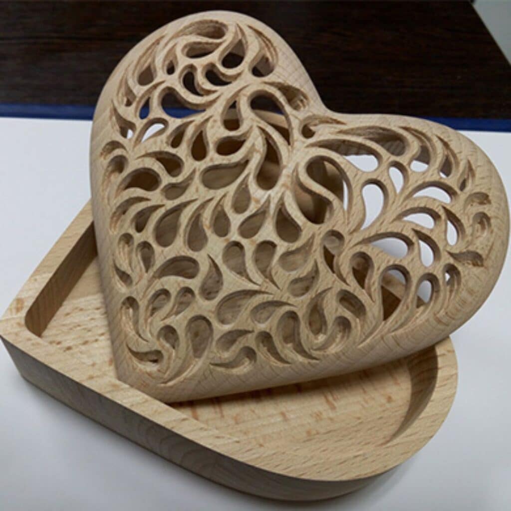 Wooden heart-shaped box with cut-outs on top.