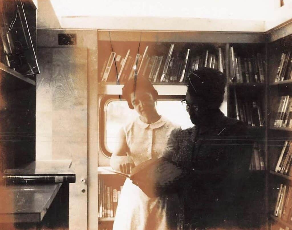 A Black woman and a white woman on a library bookmobile in 1968.