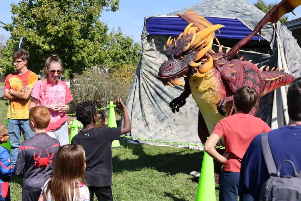 A dragon interacts with children at Comic Surge.
