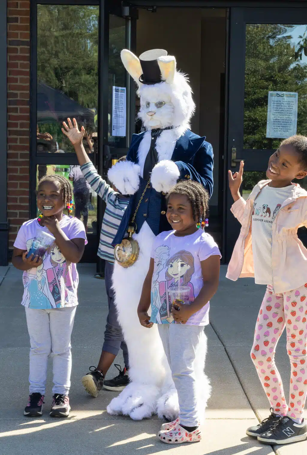 A group of children pose with the Mad Hatter.