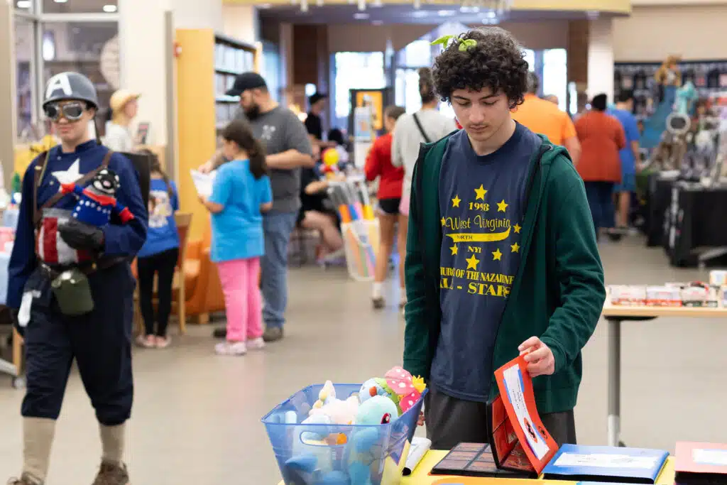 A teen checks out items at a vendor's booth.