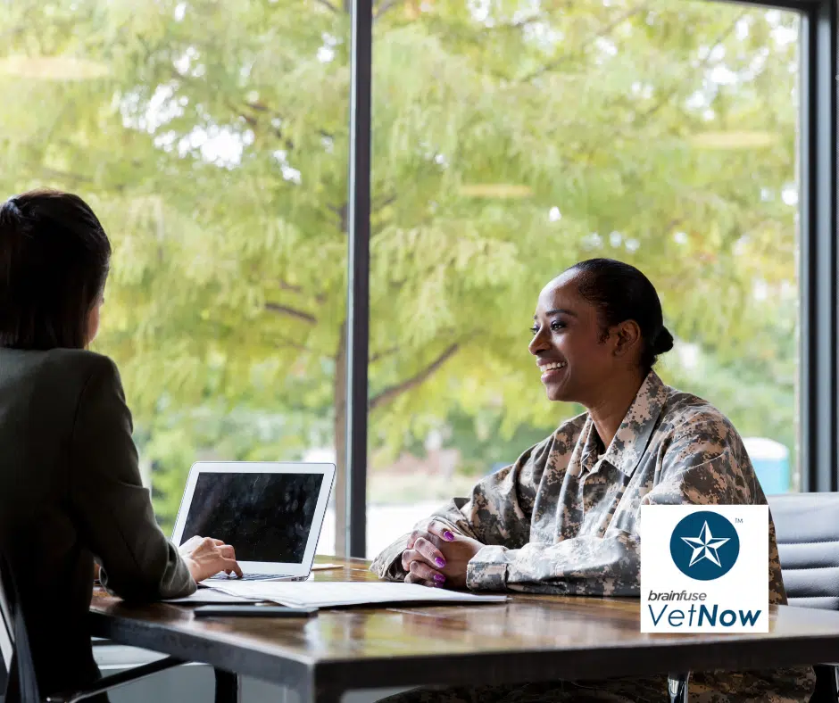 An African American woman veteran smiles as she speaks to a career counselor.